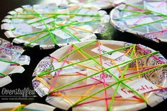 paper plates with string wrapped around them sitting on a table