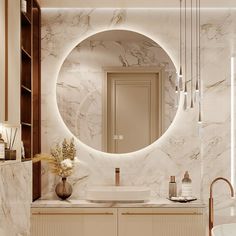 a bathroom with marble walls and flooring has a round mirror on the wall above the sink