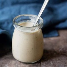 a glass jar filled with food and a spoon sticking out of the top in front of it