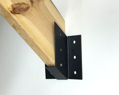 two pieces of wood that are attached to the side of a wall with metal brackets