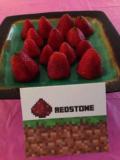 some strawberries are sitting on a plate with a sign that says redstone next to them