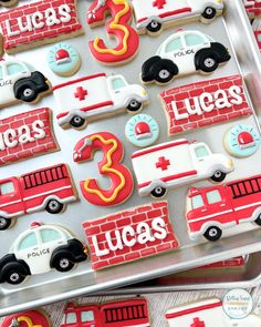 decorated cookies in the shape of firetrucks and ambulances on a tray