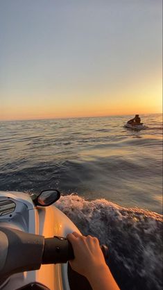 a person on a motorboat in the ocean at sunset