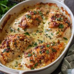 a casserole dish with chicken and cheese in it, garnished with parsley