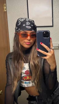 a woman taking a selfie in front of her cell phone wearing a bandana