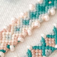 closeup of crochet and pearls on white fabric