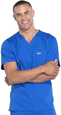 a male in a blue scrub suit with his arms crossed