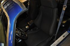 the interior of a blue car with black seats