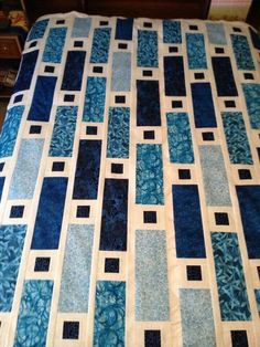 a blue and white quilt on top of a bed