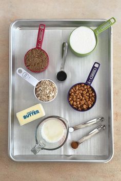 a metal tray topped with different types of food and measuring spoons on top of it