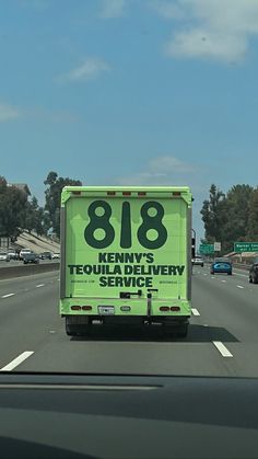 a green truck driving down a highway under a blue sky