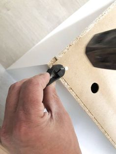 a man is using a pair of scissors to cut the edge of a piece of paper