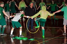 a group of young men playing a game of hula hoop on a gym floor