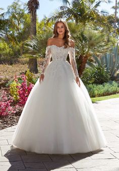 a woman in a white wedding dress posing for the camera