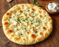 a close up of a pizza on a wooden table with other food items around it