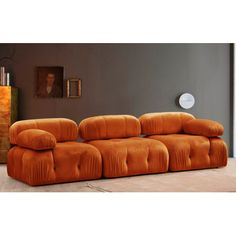 an orange couch sitting on top of a wooden floor