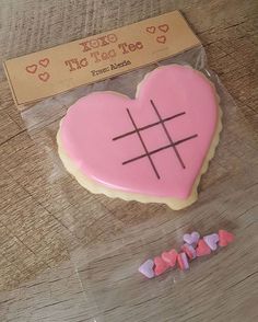 a cookie shaped like a crossword in the shape of a heart on a table