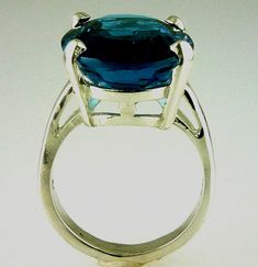 ALL OUR JEWELRY IS HANDCRAFTED IN THE U.S.A. Lovely as the clear, radiant blue of island seas... This exquisitely cut oval London Blue Topaz is of rare great size not seen in a London Blue Topaz a full 20.15 carats-- catching the light and dazzling your friends. This ring is sure to capture the attention of many admiring glances. And this great traditional design of the setting perfectly complements this great stone. Set in solid .925 sterling silver. You will love it... London Blue Topaz, (1) 2 Luxury Large Oval Topaz Ring, Large Stone Round Topaz Ring Fine Jewelry, Large Stone Topaz Ring Fine Jewelry, Oval Multi-stone Blue Topaz Gemstones, Luxury Sterling Silver Sapphire-colored Topaz Ring, London Blue Topaz Ring, London Blue Topaz, London Blue, Blue Topaz Ring