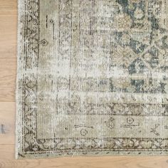 an antique rug on the floor with wood floors in the background and a wooden floor