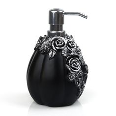 a black soap dispenser with roses and leaves on the front is shown