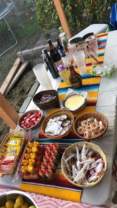 the table is covered with many different foods and drinks, including lemons, oranges, strawberries, and other snacks