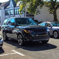 a range rover is parked on the side of the road in front of other cars