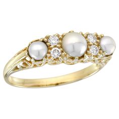 This ring exudes vintage charm with its intricate carved detailing and timeless aesthetic. The yellow gold setting provides a warm and rich backdrop for the gemstones. At the center lie three natural white freshwater pearls, their allure accentuated by the natural diamonds set in prongs, strategically placed to add sparkle and elegance. A flawless addition to any jewelry collection, this ring infuses every special occasion with a touch of vintage allure. CHARACTERISTICS Origin: Thailand Metal: S Vintage Inspired Rings, Vintage Style Rings, Timeless Aesthetic, Yellow Gold Setting, Modern Ring, Natural Pearl, Pearl Diamond, Three Stone Rings, Natural Opal