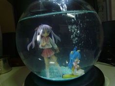 there is a fish bowl with two figurines in it