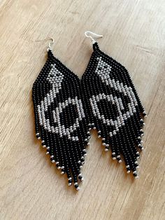 black and white beaded earrings on wooden table