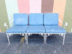 two blue chairs sitting next to each other in front of a colorful wall