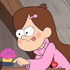 a cartoon character holding a cupcake and pointing to it with one hand on the table