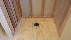 an unfinished bathroom with wood flooring and wooden studs on the wall next to the toilet