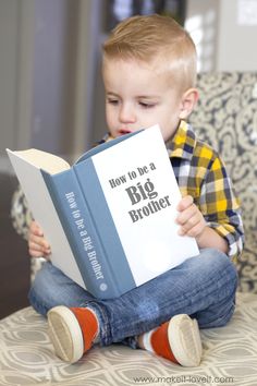 a young boy sitting on a chair reading a book with the title how to be a big brother