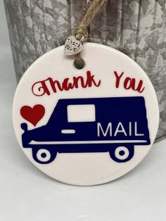 a blue and white mail truck ornament with the words thank you