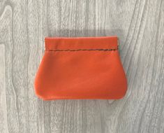 an orange purse sitting on top of a wooden table