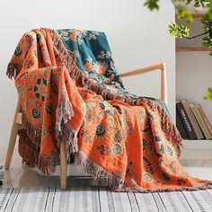 an orange and blue blanket sitting on top of a wooden chair