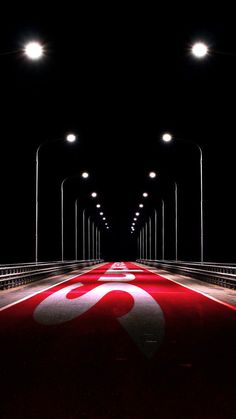 an image of a long red carpet in the middle of a dark tunnel with lights on it