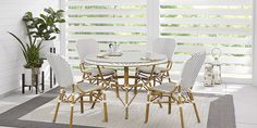 a dining room table and chairs with blinds in the background