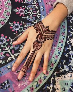 a woman's hand with henna tattoos on it