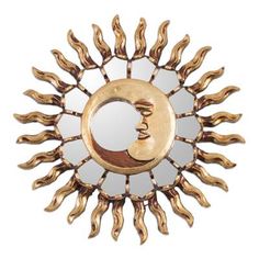 a gold sun and moon shaped mirror on a white background, with the reflection of a human face in it