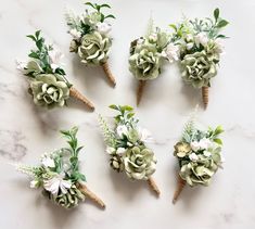 six boutonnieres are arranged in the shape of succulents and flowers