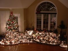 a christmas tree is in the middle of a living room with many lights on it