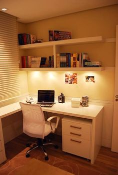 a white desk with a laptop computer on top of it next to a book shelf