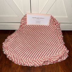 a red and white striped table cloth with a name tag on it sitting in front of a door