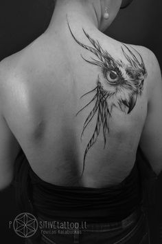 the back of a woman's shoulder with an owl tattoo on it