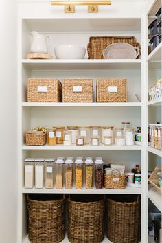 an organized pantry with wicker baskets and food items on the shelves, along with white walls