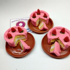 three pieces of pink cake on brown plates