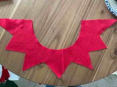 a wooden table topped with red felt pieces