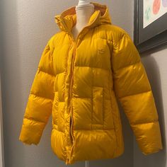 Warm And Cozy Quilted Down Puffer Coat From Adidas In Active Gold. Size Small, Oversize Fit. Full Zip, Hooded Jacket. Zippered Pockets. Hidden Inner Pocket. Monochromatic Three-Stripe Detail On Sides Underneath Sleeves. Trefoil Logo On Chest. Trendy Oversized Yellow Outerwear, Yellow Puffer Jacket For Winter, Yellow Oversized Hooded Outerwear, Trendy Yellow Long Sleeve Outerwear, Casual Yellow Outerwear For Fall, Yellow Puffer Jacket With Pockets For Cold Weather, Yellow Puffer Jacket For Cold Weather In Fall, Yellow Winter Outerwear For Streetwear, Yellow Winter Outerwear For Cold Weather