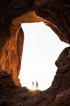 two people standing in the middle of a cave